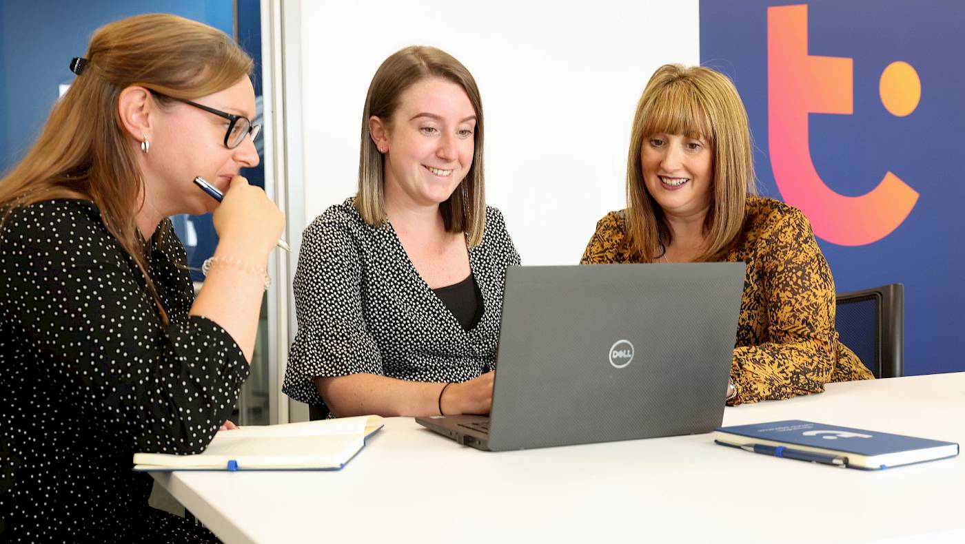 team looking at laptop, smiling