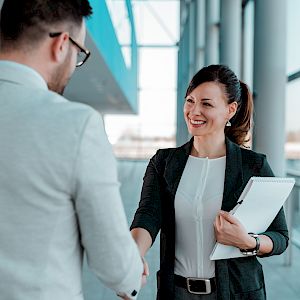 Female executive smiling and shaking hands