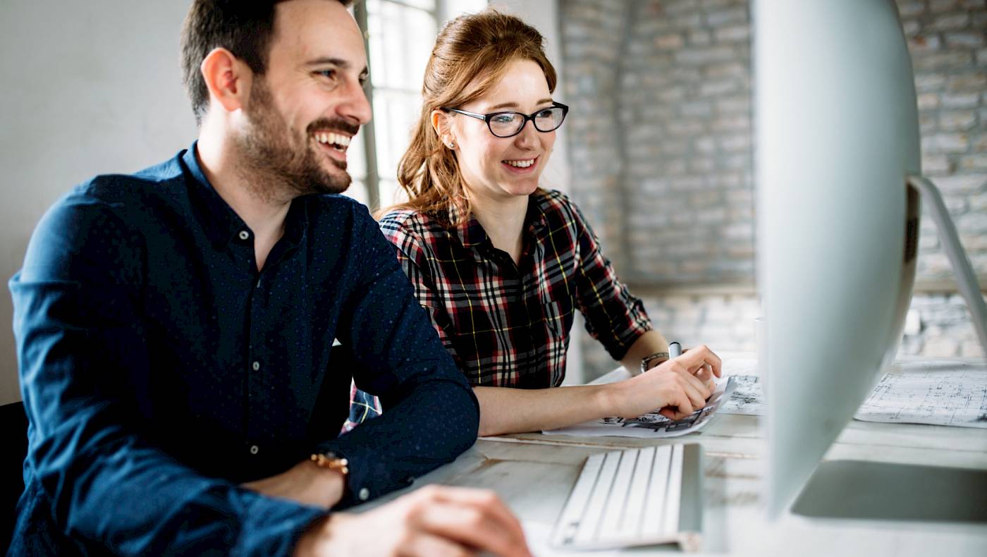 Male and female colleague sharing a computerscreen