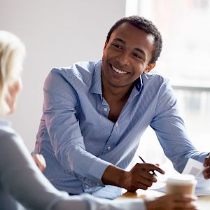 Male and female colleague talking and working with coffee