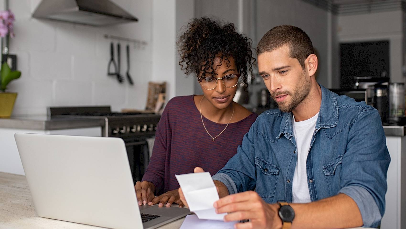 Couple sat in front of laptop viewing bills