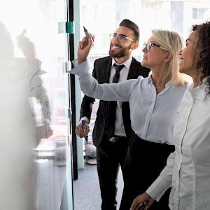 colleagues working together at a whiteboard