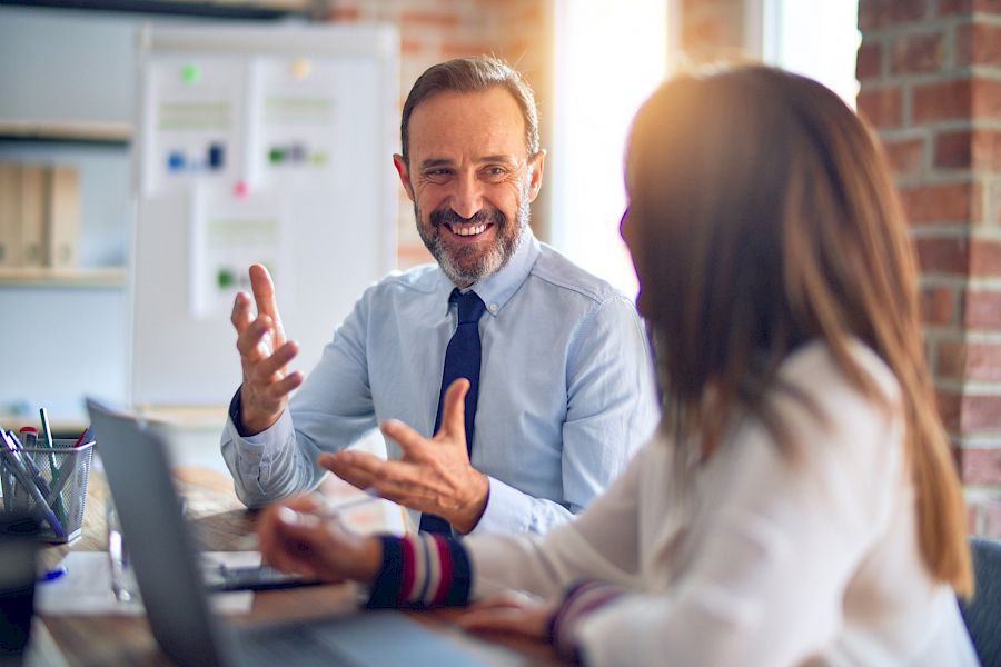 Male executive smiling and talking to female colleague