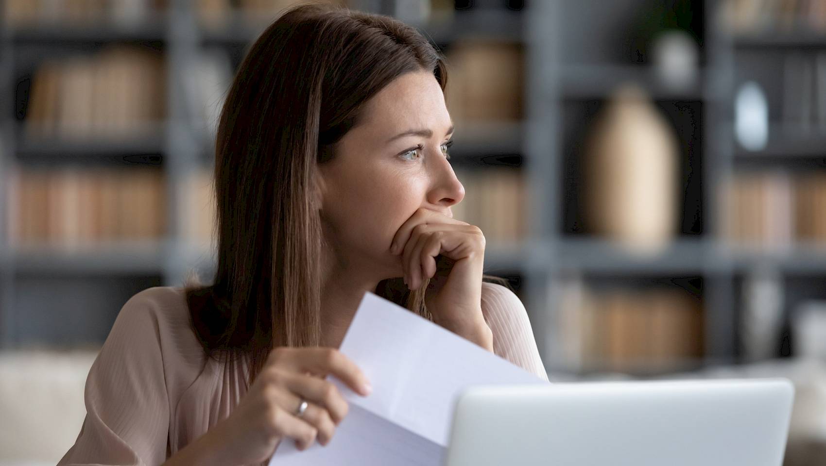 Woman looking concerned in front of laptop