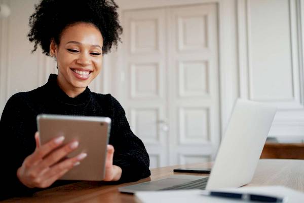 Female and male professional in office sharing laptop smiling