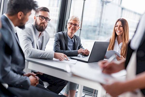 professional  female team smiling reading shared copmuter screen