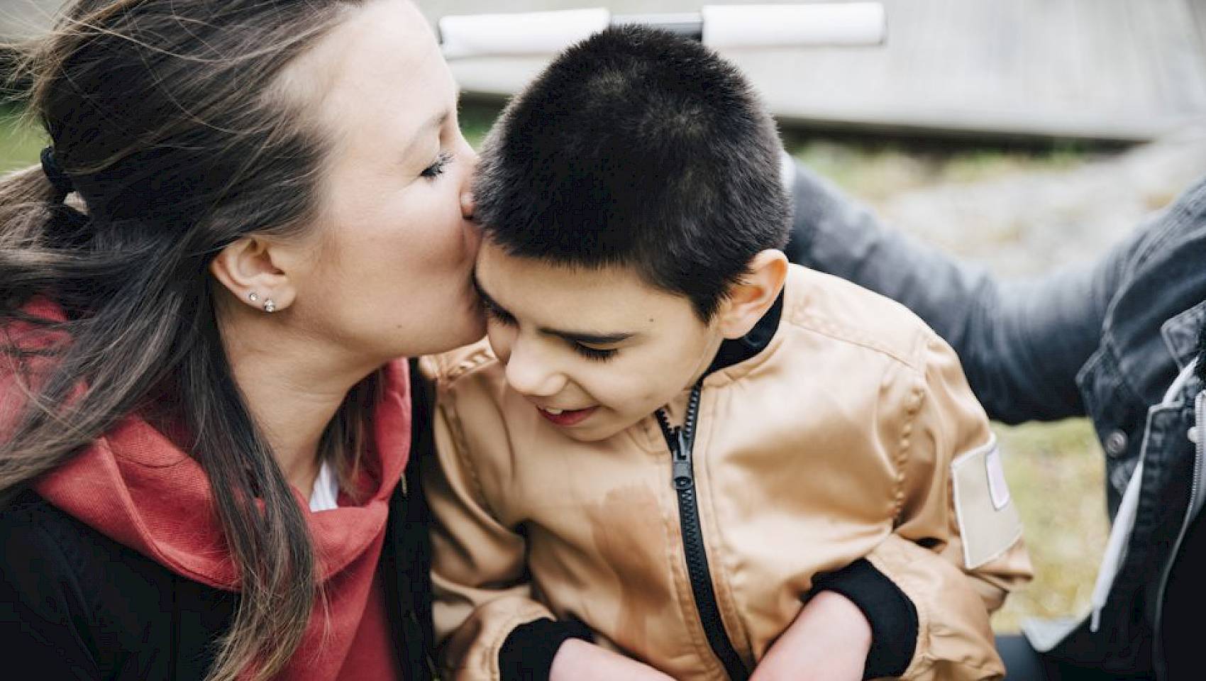 Women kissing her disabled son on the forehead