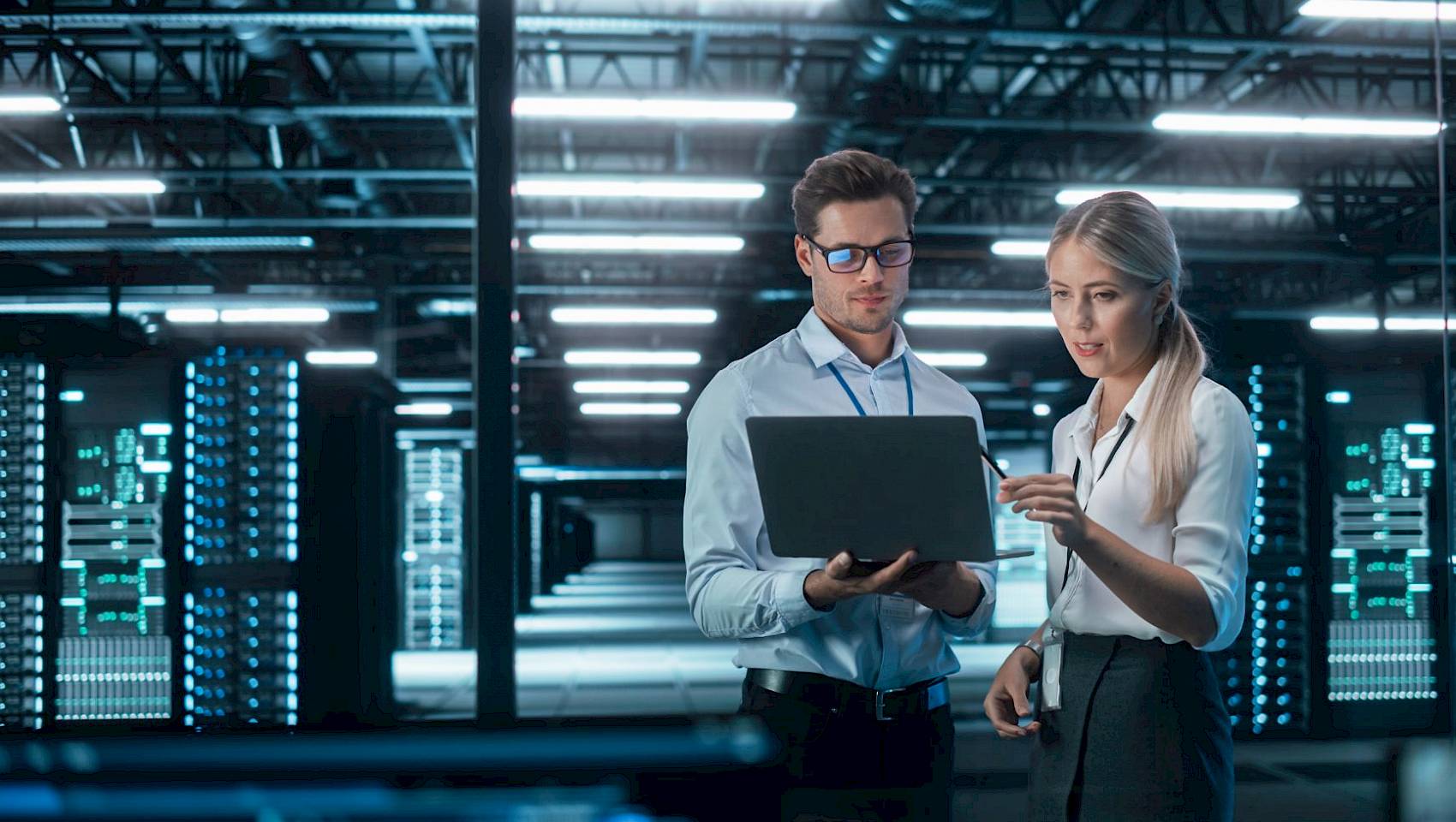 professional male and female laptop in computer server room