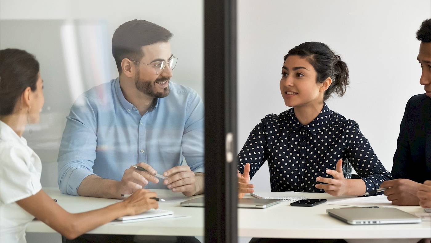 Diverse team in meeting lead by Indian woman