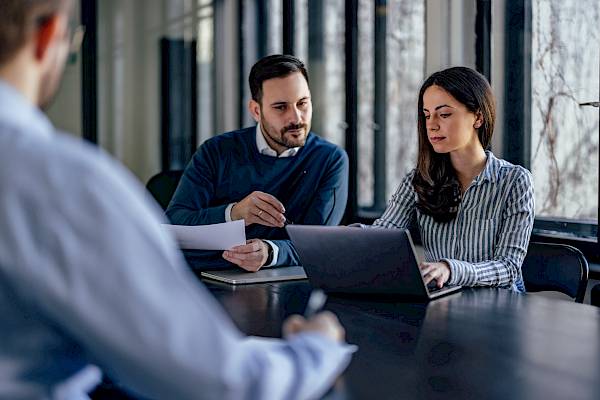 male and femal colleague looking at laptop screen and concentrating