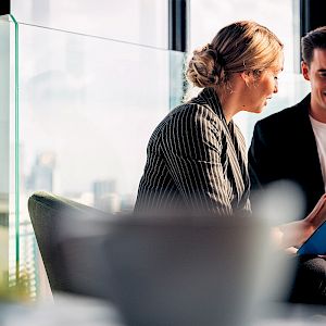 Male and female in office looking at proposal