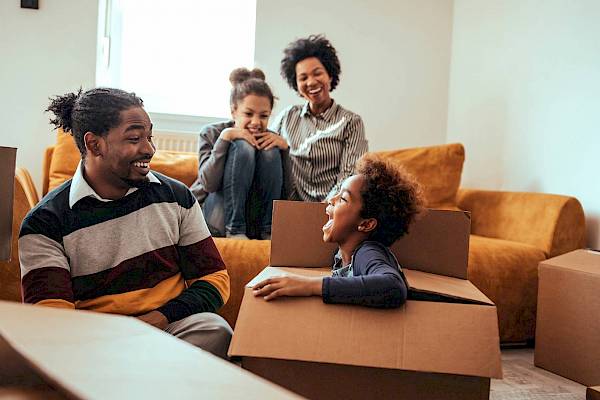 Family unpacking boxes in new house