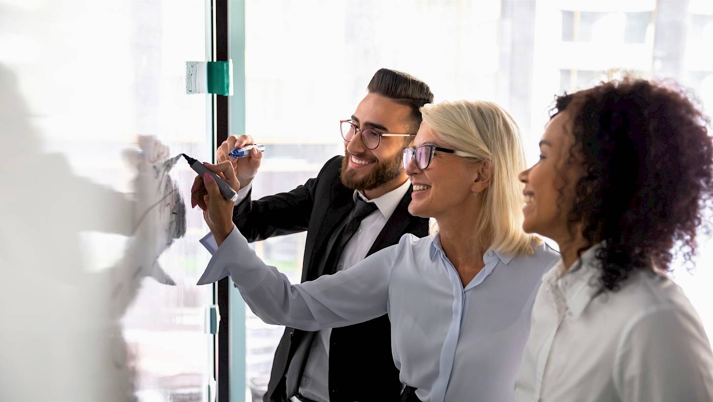 Colleagues writing notes on a board