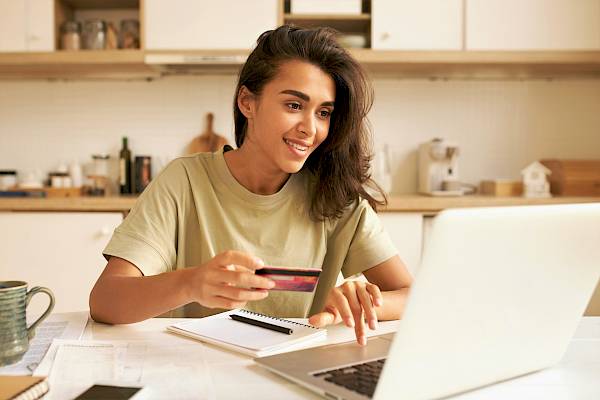 Young female making a puchase via laptop and inputting credit card details