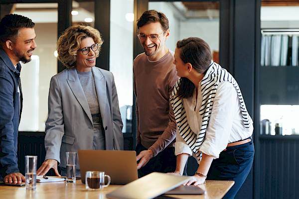 Team of professionals smiling at laptop