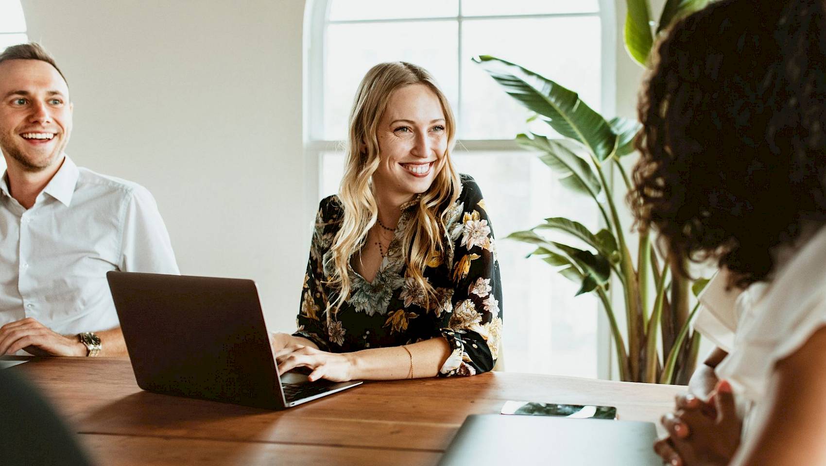 professional female team smiling reading shared computer screen