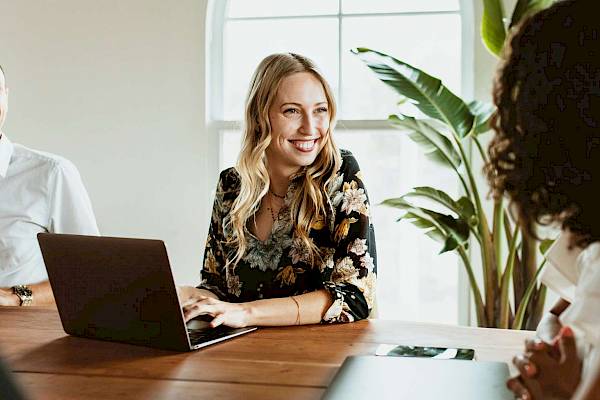 professional  female team smiling reading shared copmuter screen