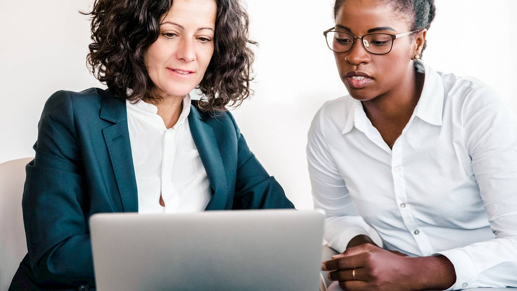 professional females looking at a laptop screen concentrating