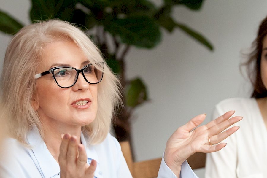 Smart executive woman with glasses talking in a meeting