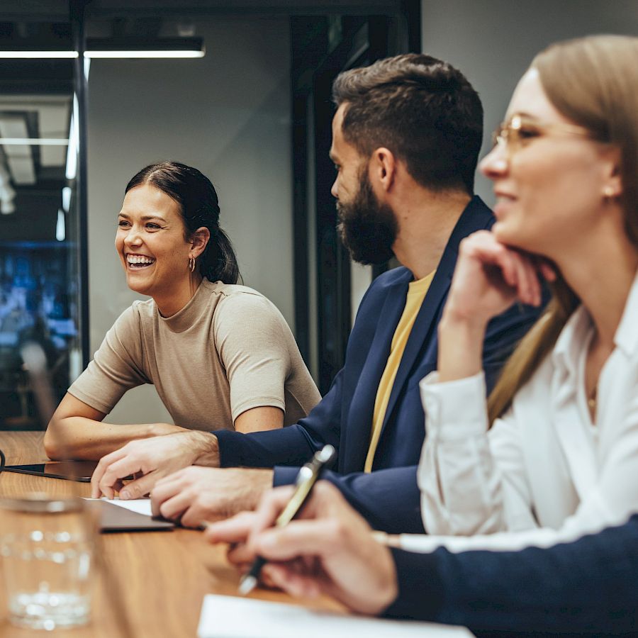 Team of colleagues in meeting room smiling